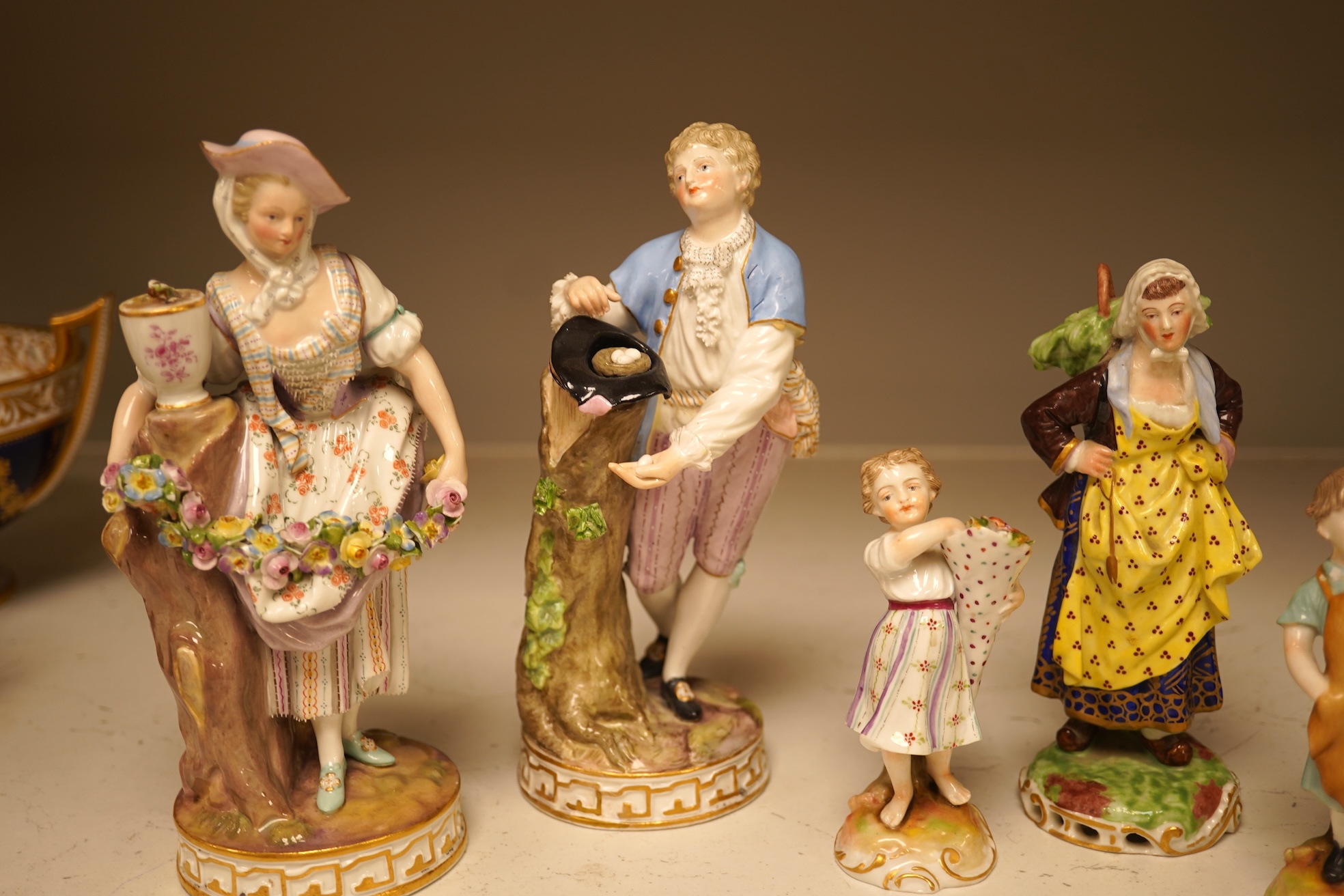 A pair of 19th century Meissen figurines, a Crown Derby figure, a pair of miniature figures and a Leeds type creamware group of Venus and Cupid, tallest 18cm high.